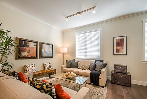 A small, bright living room with beige couches and  indoor plants, near where RL Property Management provides Franklin County property management