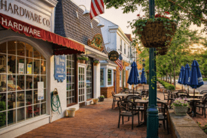 Historic downtown Worthington Ohio street with brick sidewalks, small storefronts, outdoor seating, and tree-lined walkable area