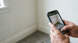 Smartphone camera taking picture of a moldy corner in a rental unit called this Ohio security deposit. 