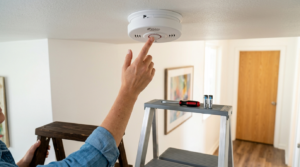 Maintenance technician testing smoke alarms in rental property 